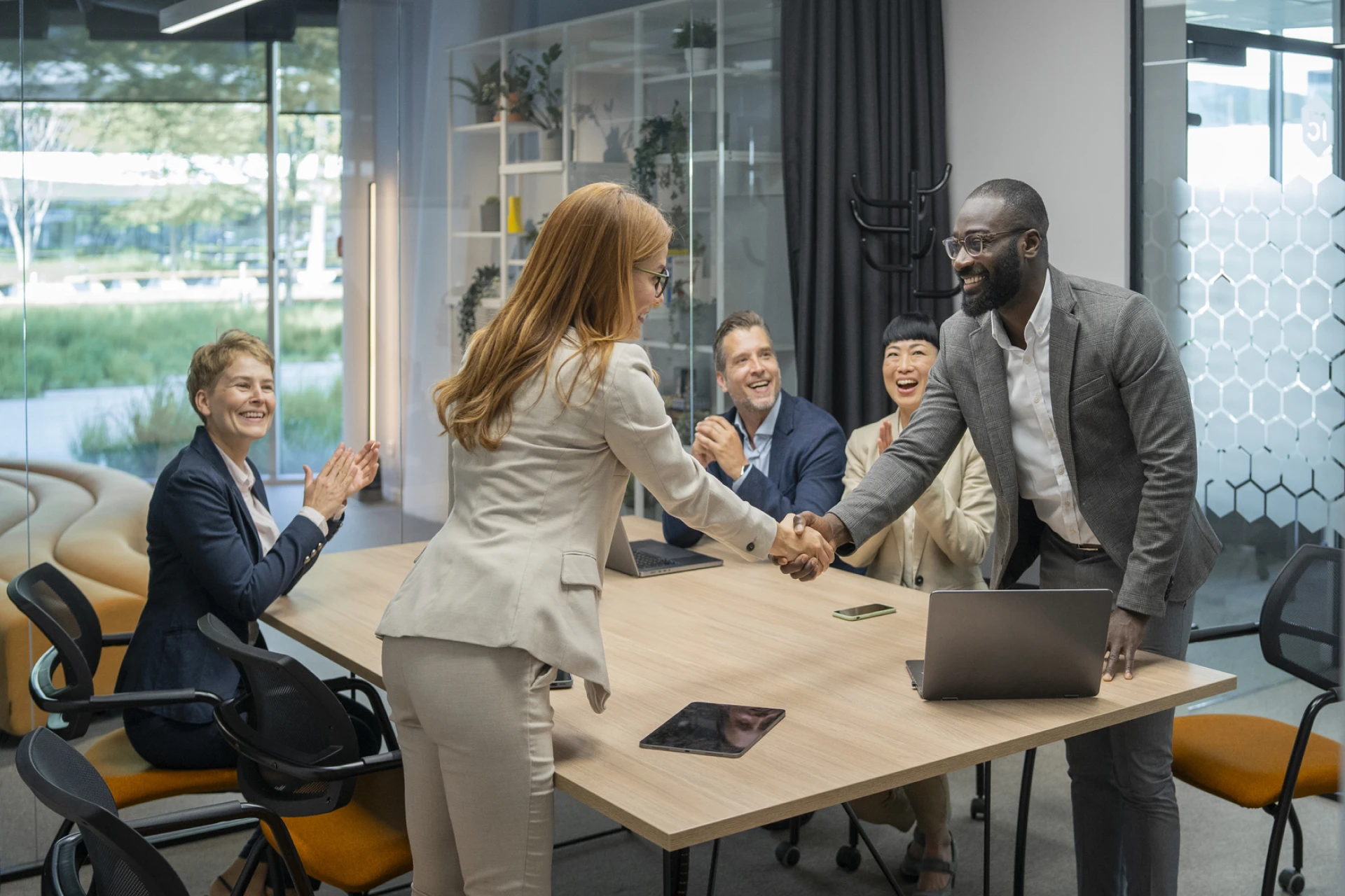 Group of people sitting around a table, and shaking hands